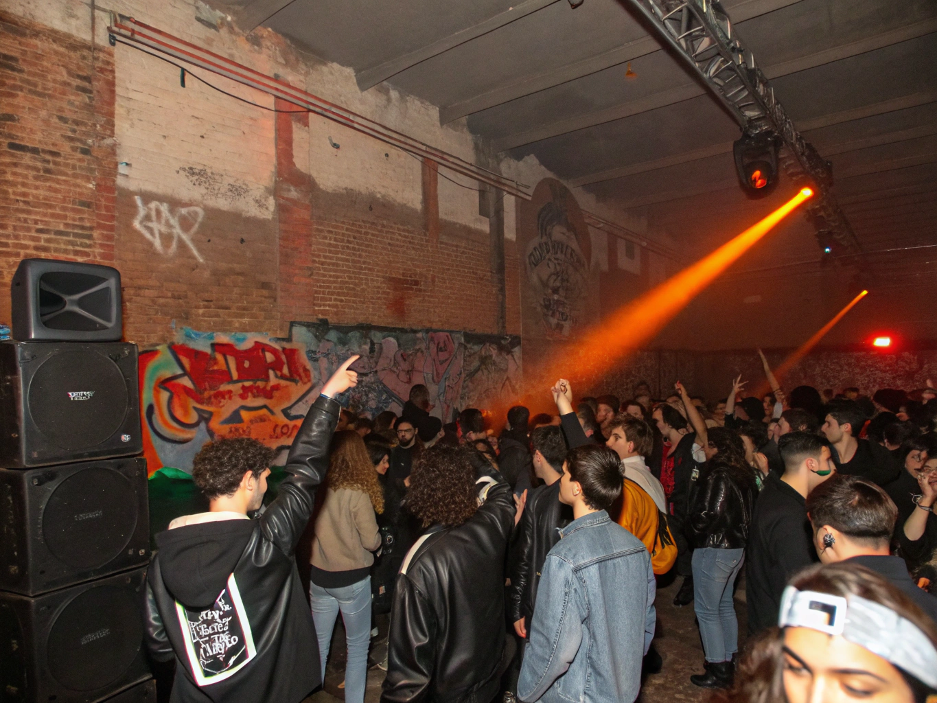Sweat-soaked mosh pit and crowd jumping under spotlights