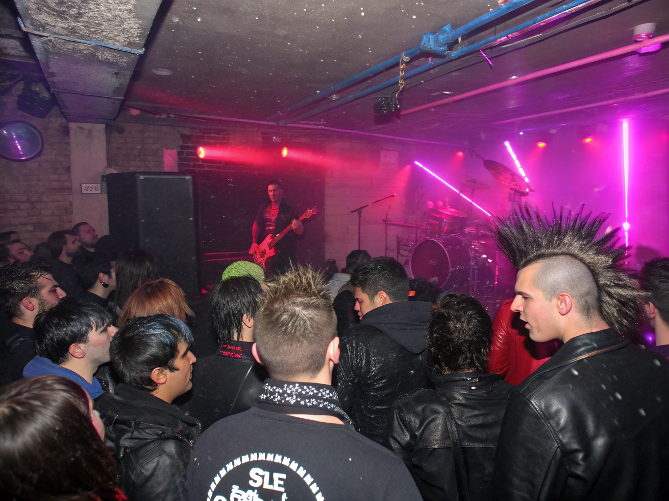 High energy mosh pit under green stage lights